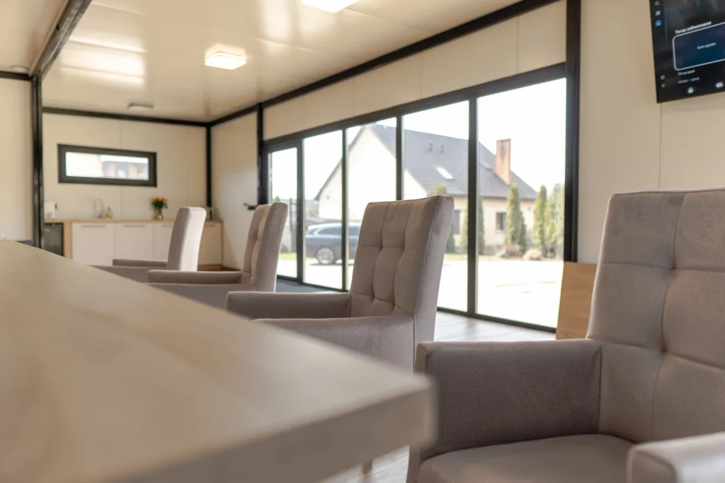 Wnętrze kontenera 10x6 zaaranżowane jako biuro typu open space.