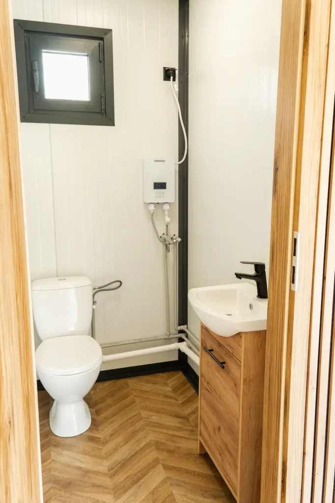 Szafka z umywalką w łazience kontenera biurowego z WC, produkcja MODUVO
